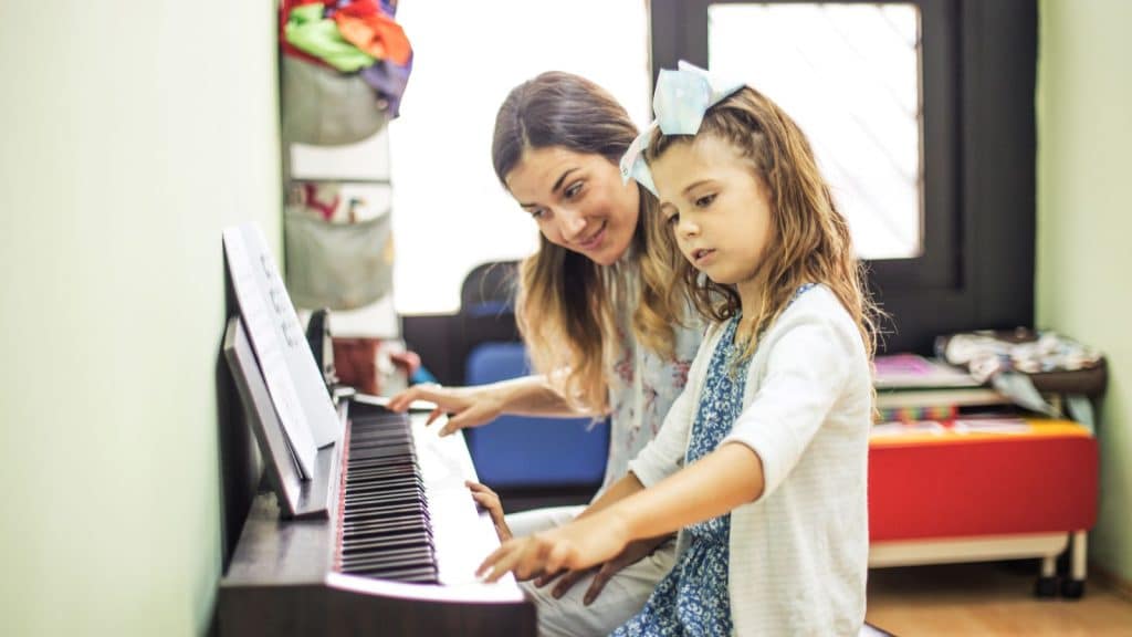 A Piano Teacher with her Little Girl Student